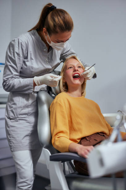 istock Woman performing a dental procedure on a patient 1354179852