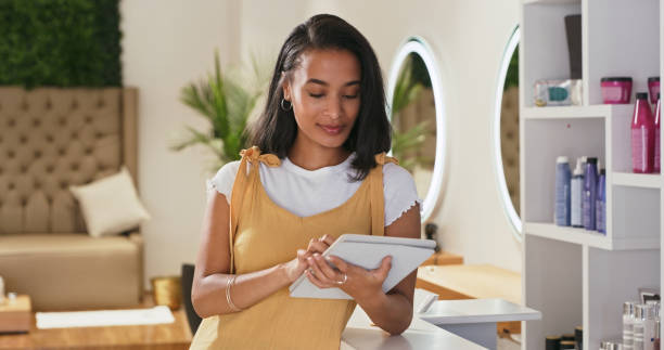 istock Shot of a young female receptionist using a digital tablet at a salon 1354180864