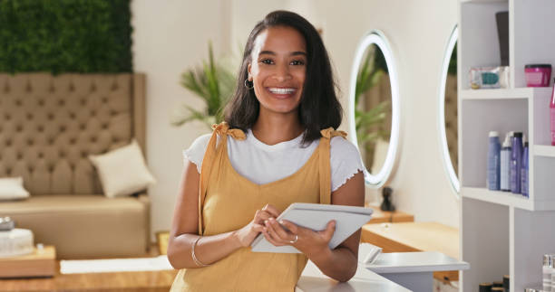 istock Shot of a young female receptionist using a digital tablet at a salon 1354180935