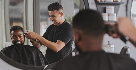 Shot of a handsome young man getting his hair cut at the barber