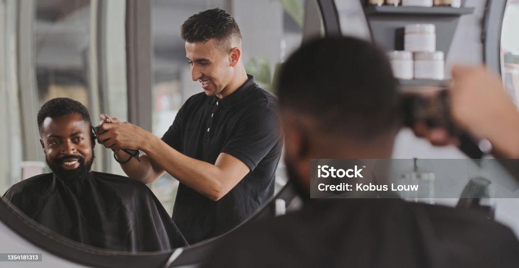 Shot of a handsome young man getting his hair cut at the barber This is where I come to get a cut that's on point Barber Shop Stock Photo