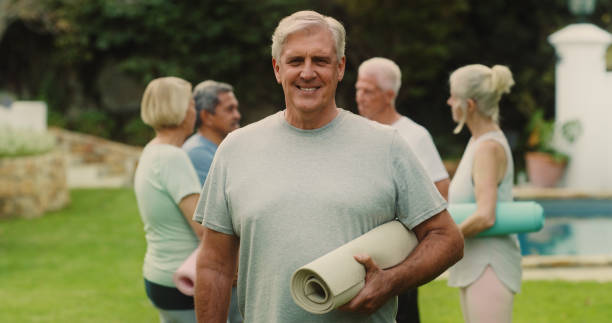 istock Portrait of a man holding his mat while attending a group yoga class 1354182005