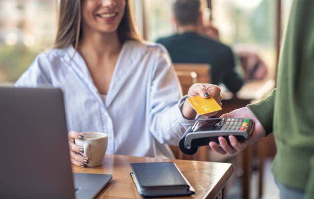 Woman In Cafeteria Paying With Credit Card stock photo