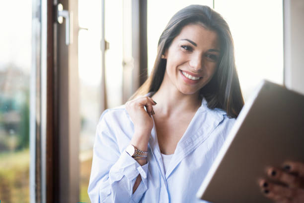 istock Portrait Of A Smiling Woman Using A Digital Tablet 1354182089