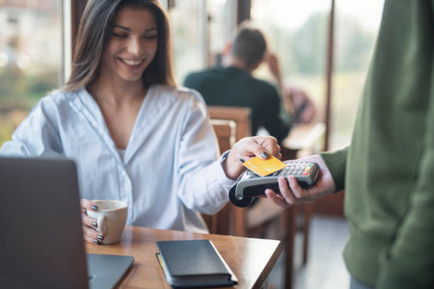 istock Businesswoman Making Credit Card Payment While Working In Cafe 1354182090