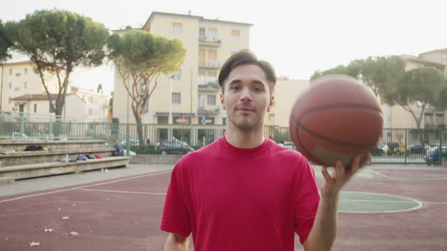Portrait of a young adult man standing in a pick-up basketball court