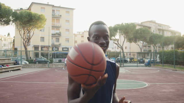 Portrait of a young adult man holding a basketball ball