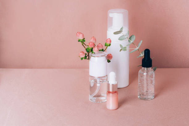 istock Glass bottles on a shiny pink fabric background. Front view 1354183656