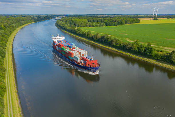 istock Container ships on the Kiel Canal and windmill on the background. 1354183693
