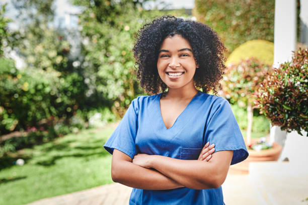 istock Shot of an attractive young nurse standing alone outside with her arms folded while working at an old age home 1354184030
