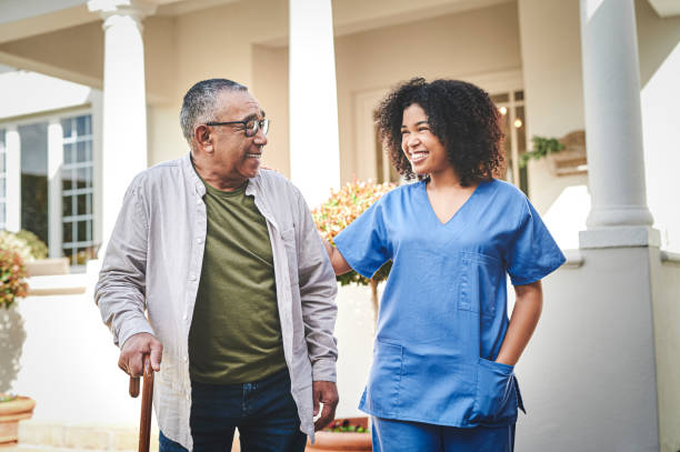 istock Shot of a senior man using a walking stick outside while his nurse helps him 1354184164