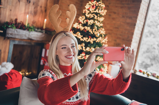 Photo of young cheerful girl happy positive smile headband reindeer make selfie costume christmas winter indoors.