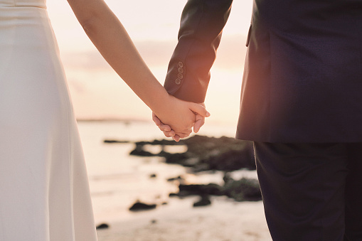 Rear view of a married couple walking on the beach