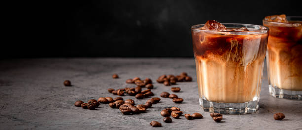 istock Ice coffee in a glass with cream poured over 1354189094