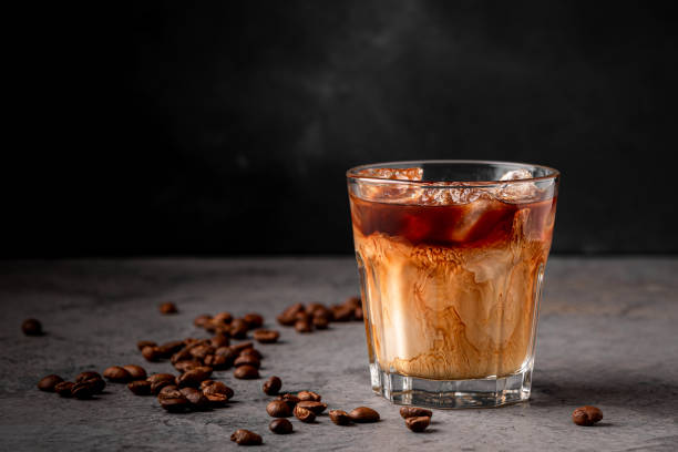 istock Ice coffee in a glass with cream poured over 1354189123