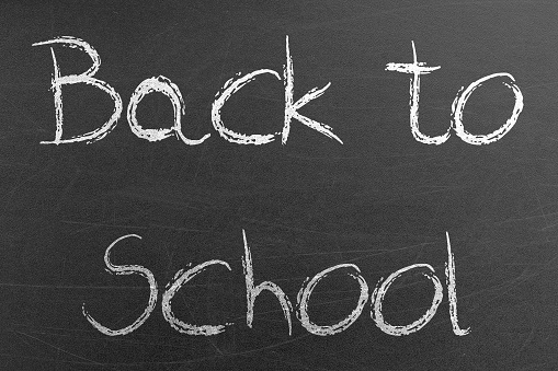 Back to School word handwritten by chalk on a university blackboard. Education and science concepts and backgrounds