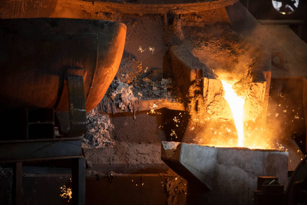 istock Molten metal pouring into the foundry mould 1354189698