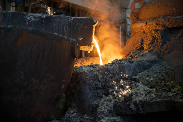 istock Molten metal pouring into the foundry mould 1354189704