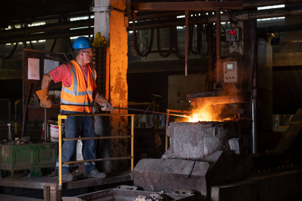 istock Mature man checking molten metal in steel mill 1354189708