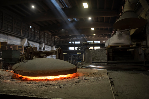 View of iron being melted down in the hot furnace of steel mill.