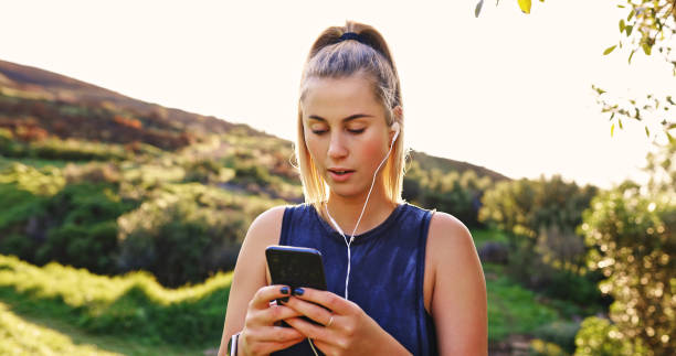 istock Shot of a young woman using her smartphone during a workout 1354190086