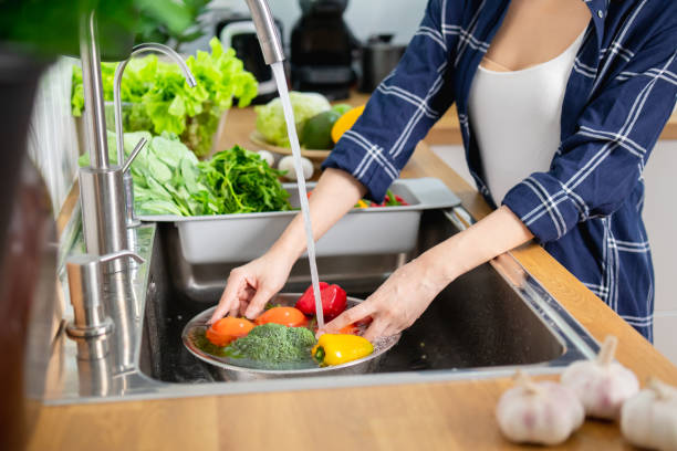 Close up Asian healthy woman washing vegetable above kitchen sink, preparing eat cleaning food stock photo