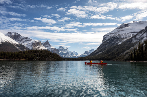 Tourists canoeing into the Spirit Island with Canadian Rockies on Maligne lake at Jasper national park, AB, Canada