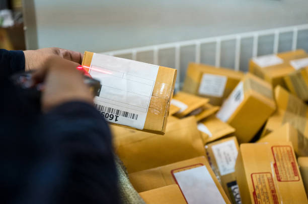 istock Delivery man using laser scanner scanning parcel cardboard box in distribution center 1354191046