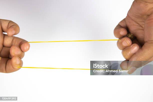 Hand Stretch Rubber Band On A White Background Stock Photo - Download Image Now - Rubber Band, Stretching, Backgrounds