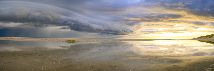 Sunrise at the beach at Texel island with a storm cloud approaching over the Wadden sea at the North point of the island facing the Wadden Sea and Vlieland.