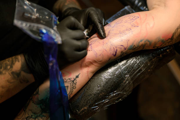 istock Professional male bearded caucasian tattoo master is working in cozy atmospheric studio 1354192531