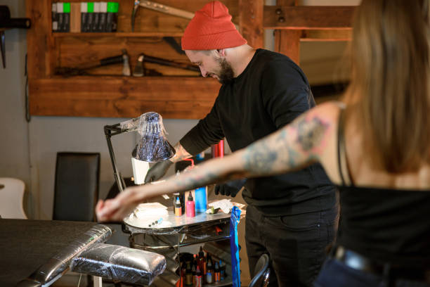istock Professional male bearded caucasian tattoo master is working in cozy atmospheric studio 1354192566