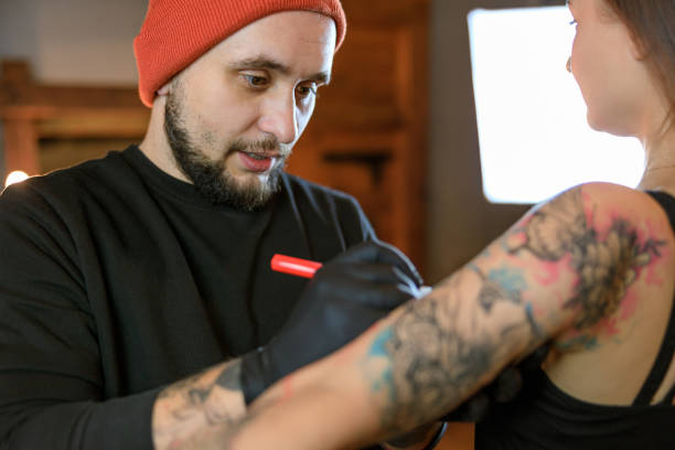 istock Professional male bearded caucasian tattoo master is working in cozy atmospheric studio 1354192571
