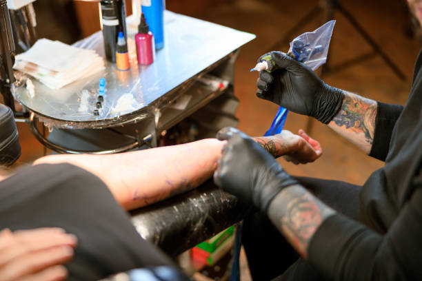 istock Professional male bearded caucasian tattoo master is working in cozy atmospheric studio 1354192589