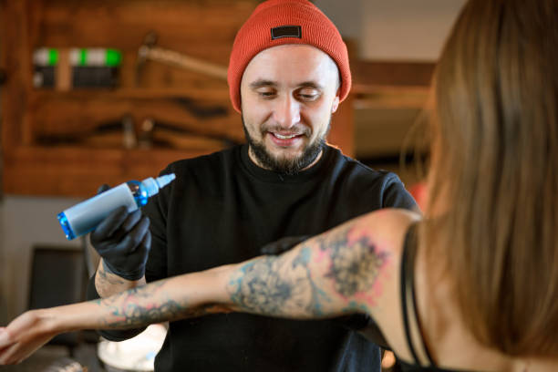 istock Professional male bearded caucasian tattoo master is working in cozy atmospheric studio 1354192605