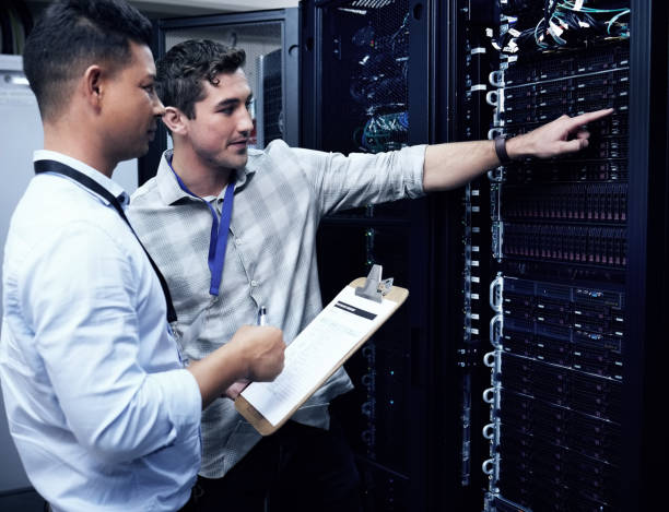 istock Shot of two technicians working together in a sever room 1354192750