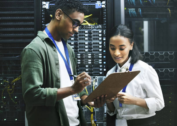 istock Shot of two technicians working together in a sever room 1354192766