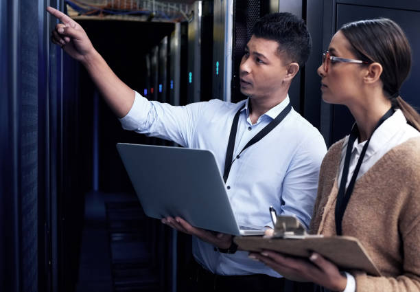 istock Shot of two technicians working together in a server room 1354192770