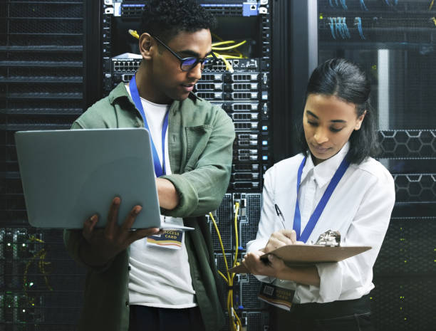 istock Shot of two technicians working together in a server room 1354192777