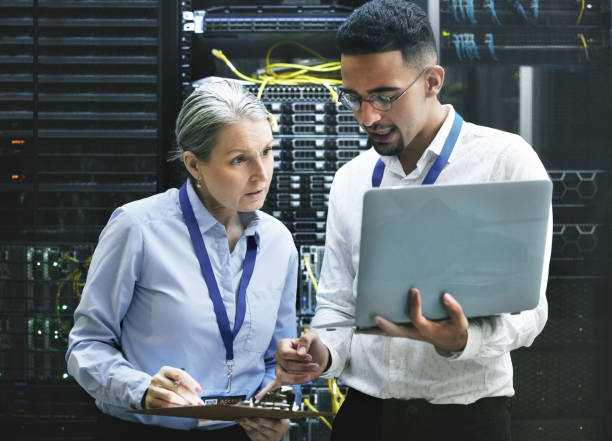 istock Shot of two technicians working together in a server room 1354192787