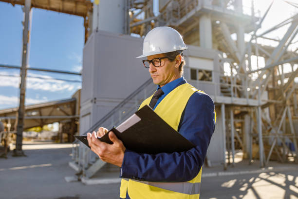 istock Male engineer writing documents outdoors at factory 1354192858