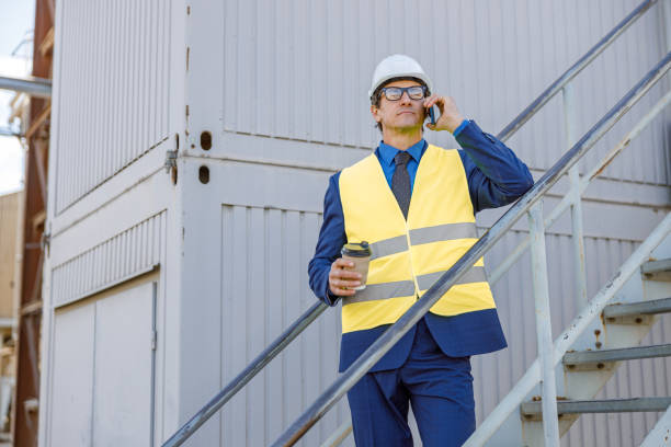 istock Male engineer talking on mobile phone outdoors at factory 1354192860