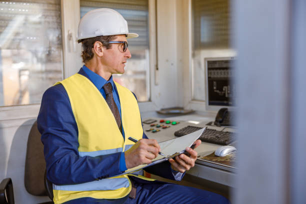 istock Male engineer writing documents at manufacturing plant 1354192866