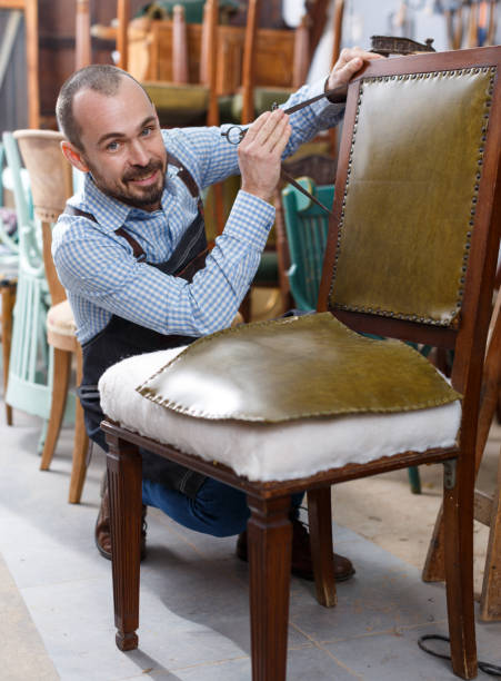 istock Craftsman reupholstering chair in workshop 1354192945