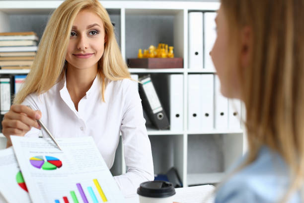 istock Two smiling women working together in the office 1354194151