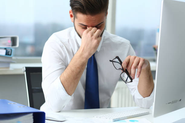 istock Busy guy holding glasses at the desktop 1354194155