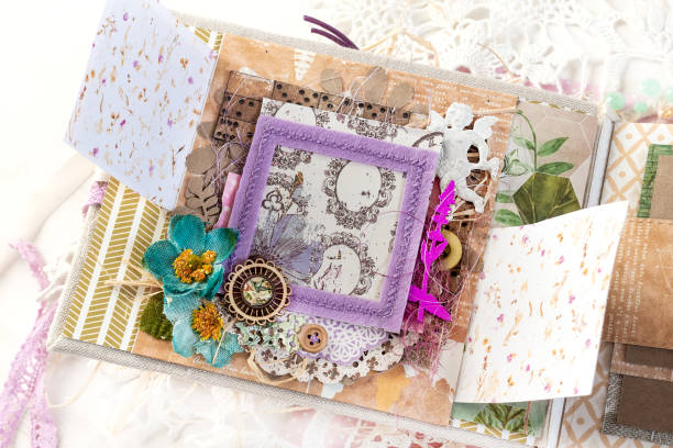 istock Scrapbooking handmade photo album. Diy. Top view on table with elements for scrapbooking, cut paper, die cuts, paper flowers, ribbons,embossing. Pastel colors. Women's hobby 1354194207