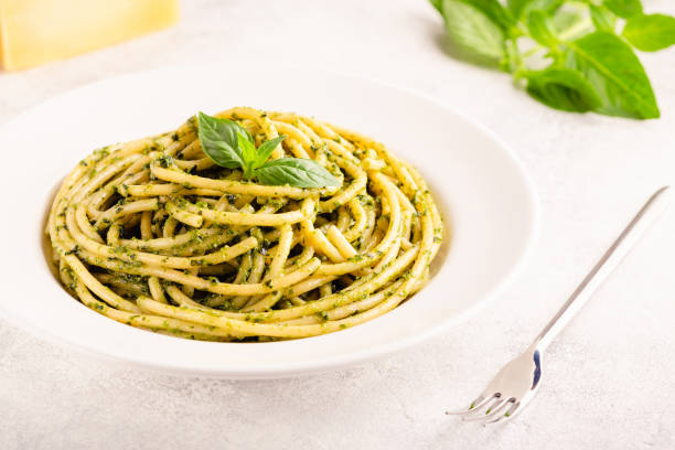 istock Pasta spaghetti with pesto sauce and fresh basil leaves 1354195042