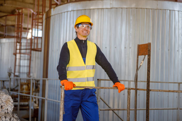 istock Cheerful man engineer standing near meta storage container at factory 1354196090