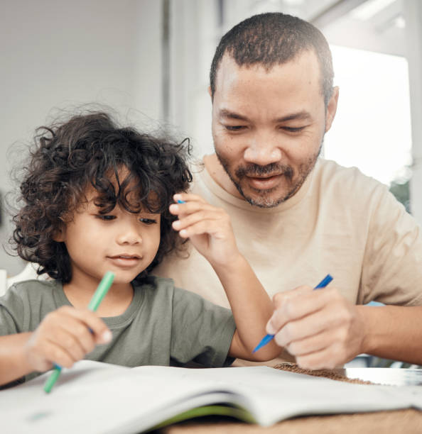 istock Shot of a man helping his son with his homework 1354196173